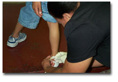 Woman putting bandage on child's ankle.