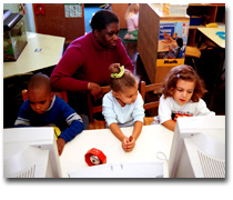 children at computers with teacher observing