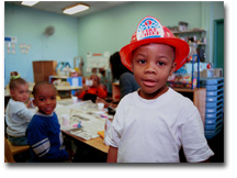 boy dressed in fire fighter's cap